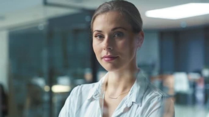 一位成功的女商人经理独自站在办公室的肖像。自信而雄心勃勃的女性专业人士在工作空间和看着相机时感觉强大