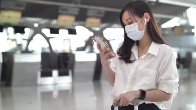 亚洲妇女在机场使用智能手机戴口罩