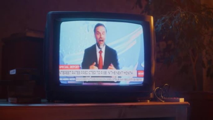 用突发新闻报道特写过时的电视机屏幕的镜头。英俊的中年主持人在电视直播中阅读重要新闻。怀旧复古90年代