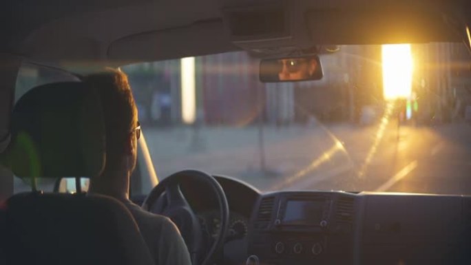 日落背景下的人开车。变形镜头拍摄