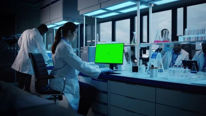 现代医学研究实验室: 在计算机上工作的女性科学家的肖像，显示绿色色度键屏幕。先进科学实验室，医药开发