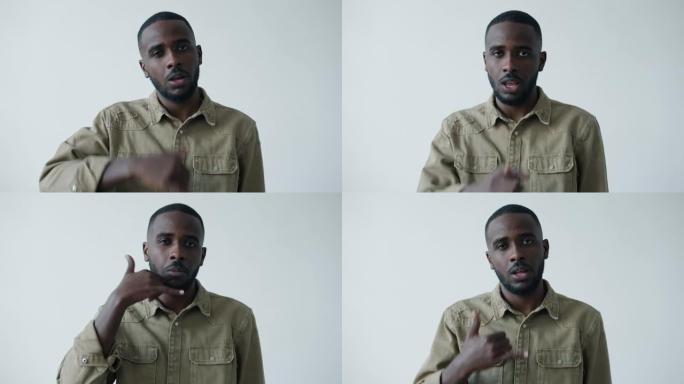 漂亮的美国黑人男子的肖像，用手机手势指着相机