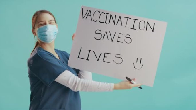 4k视频片段，一名护士独自站在诊所并戴着口罩，同时举着牌子