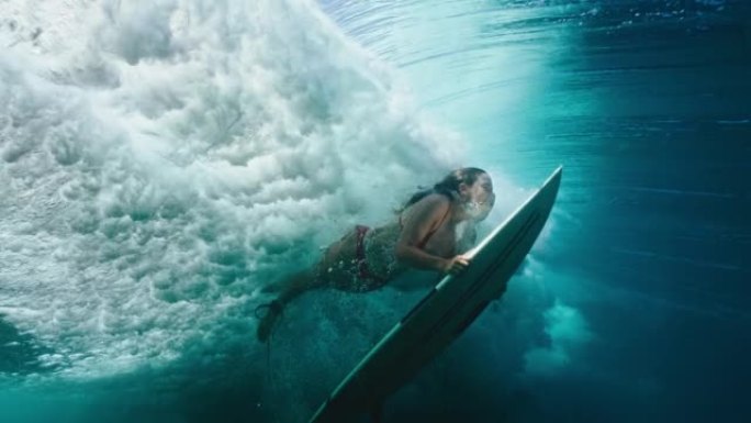 冲浪女孩在海浪下潜水