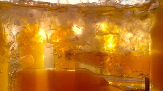 超级SLO MO将瓶子倒入装满水和冰块的冷却器中