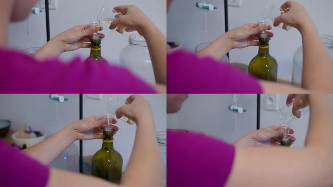 一名妇女将薰衣草油液体倒入瓶子中
