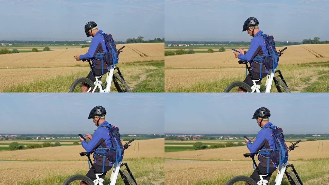 SLO MO Mountain biker在乡下某个地方休息时使用智能手机