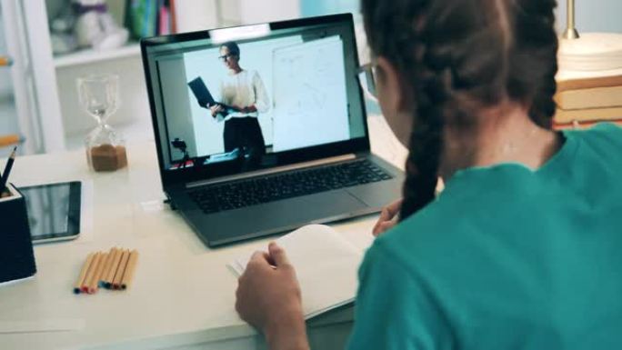 十几岁的女孩使用笔记本电脑与老师交流，在线课程概念。
