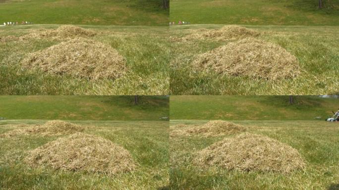 特写: 春季充气后，在后院草坪上倾斜成堆的干草毡