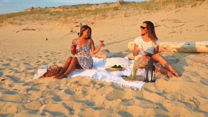 WS两名年轻女子在沙滩上喝一杯饮料