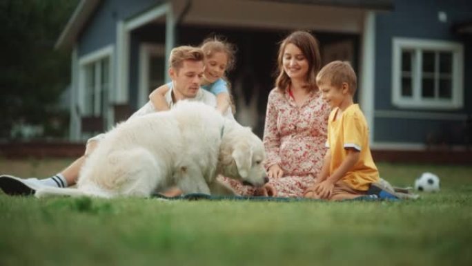 一对快乐的家庭夫妇带着孩子的肖像，玩耍和抚摸着一只美丽的白色金毛猎犬。快乐的成功人士坐在房子前面前院
