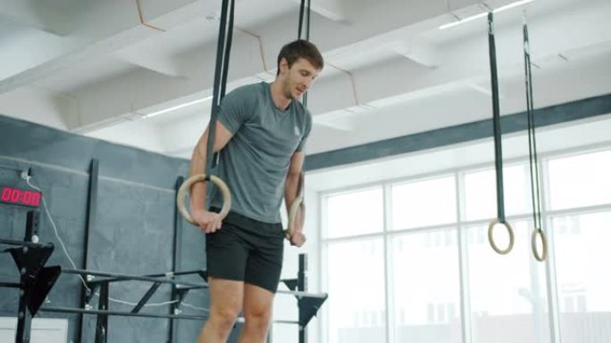 在激烈的运动训练中，一个人在吊环上运动的慢动作