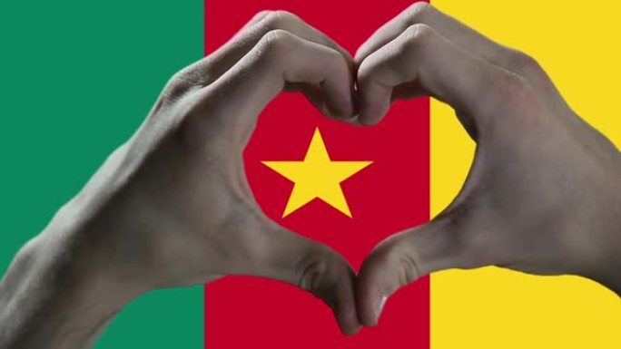 双手在喀麦隆国旗上显示心脏标志。