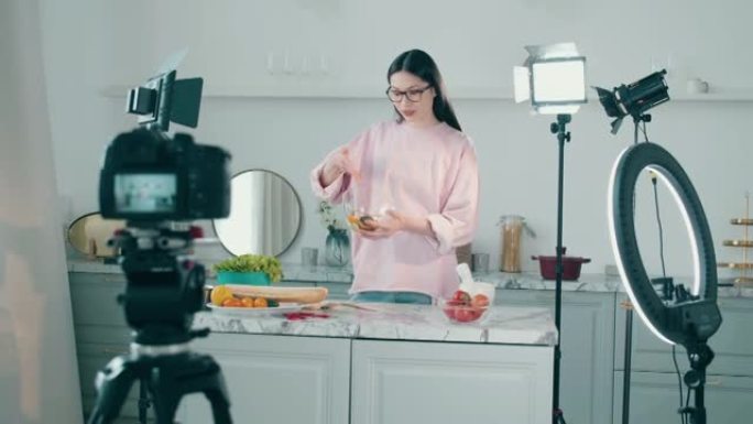 拍摄时，一名妇女正在录像带里做饭。在线vlog概念，女性博主录制视频，在线流媒体概念。