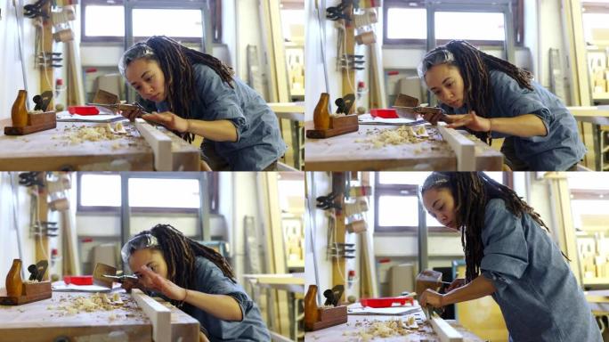 女木匠在木工店里用木槌和凿子雕刻木头