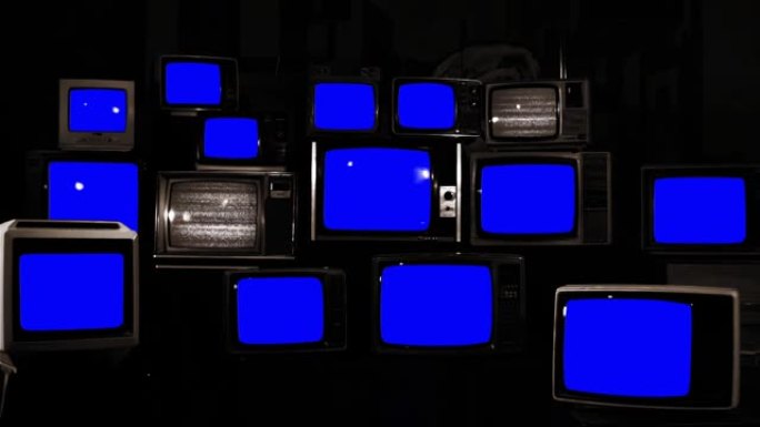 成堆的复古电视打开和关闭蓝色色度屏幕。您可以用所需的素材或图片替换蓝屏。您可以在After Effe