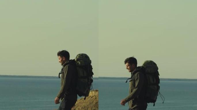 背着背包的男人在海边的山上行走
