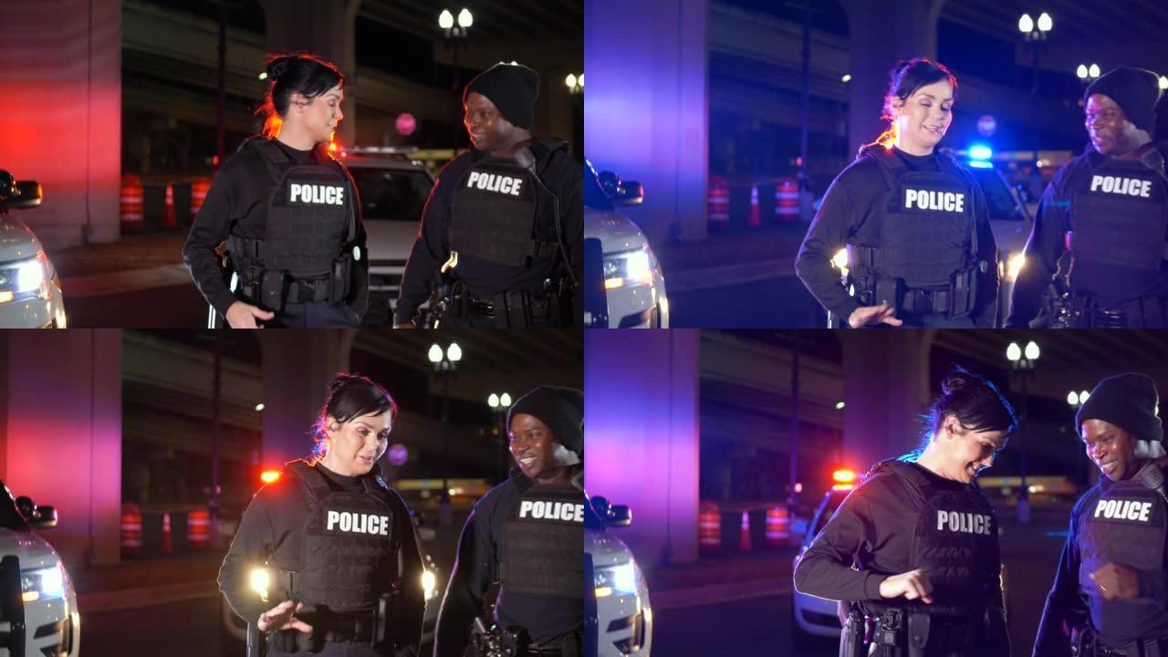 两个警察在晚上工作，聊天，碰碰拳头
