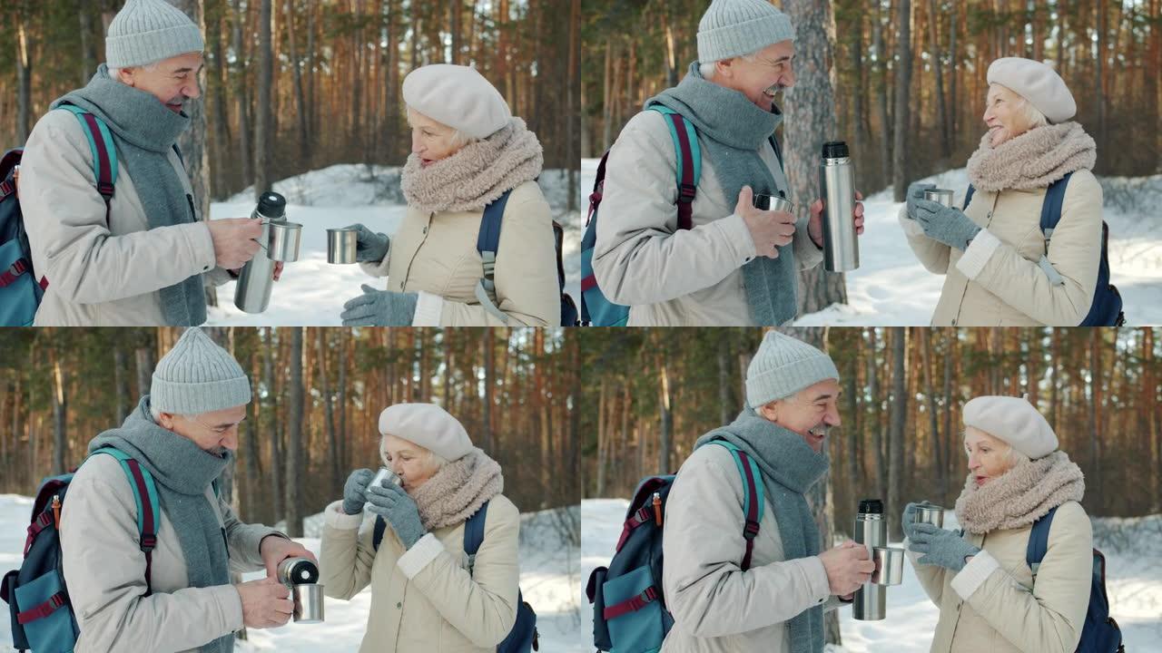 冬季在森林里喝热水瓶的高级男女游客