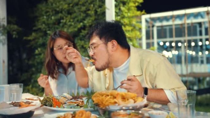 夫妇在亚洲餐厅享用和分享木瓜沙拉，享受晚餐。