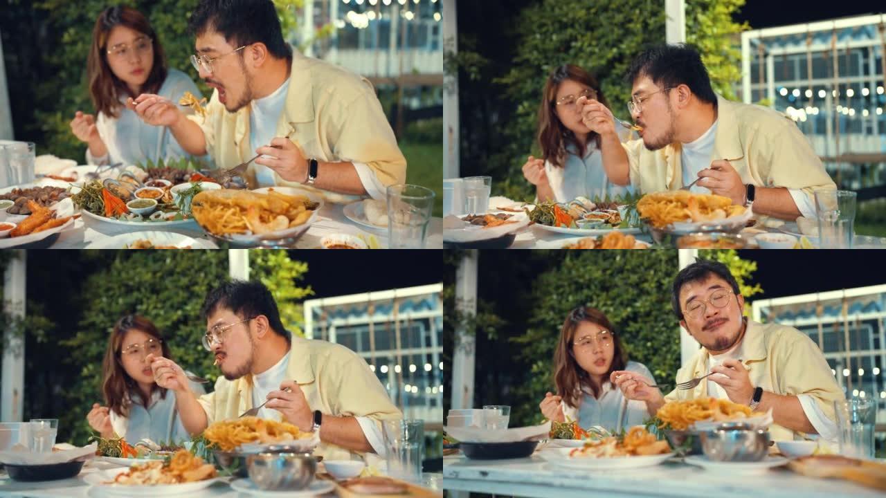 夫妇在亚洲餐厅享用和分享木瓜沙拉，享受晚餐。