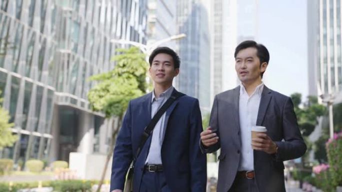 两名亚洲商人在市中心金融区的街道上聊天