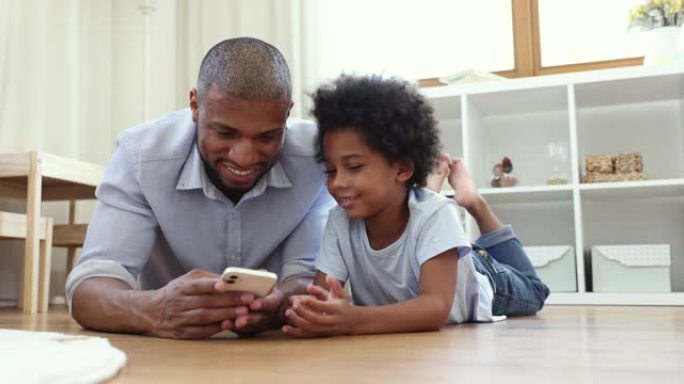 非洲爸爸他的小儿子用现代智能手机度过闲暇时光