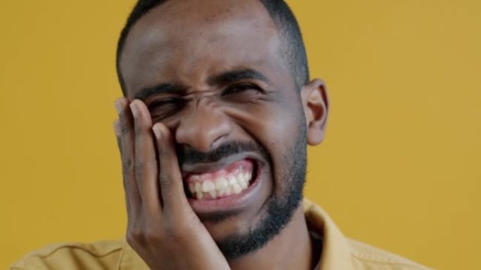 生病的非洲裔美国男子的特写慢动作肖像牙痛抱着脸颊