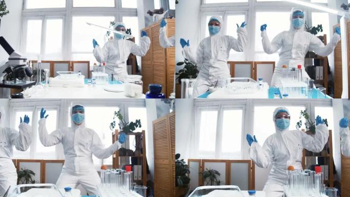 庆祝成功。两个兴奋的疯狂快乐的女性化学实验室医生穿着白色防护服在工作中做有趣的舞蹈。