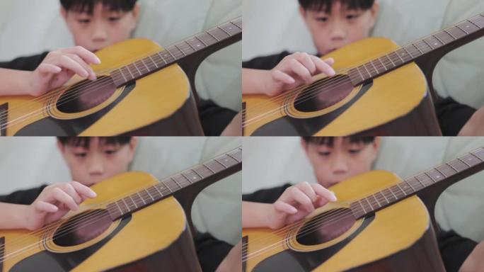 玩原声吉他的亚洲男孩