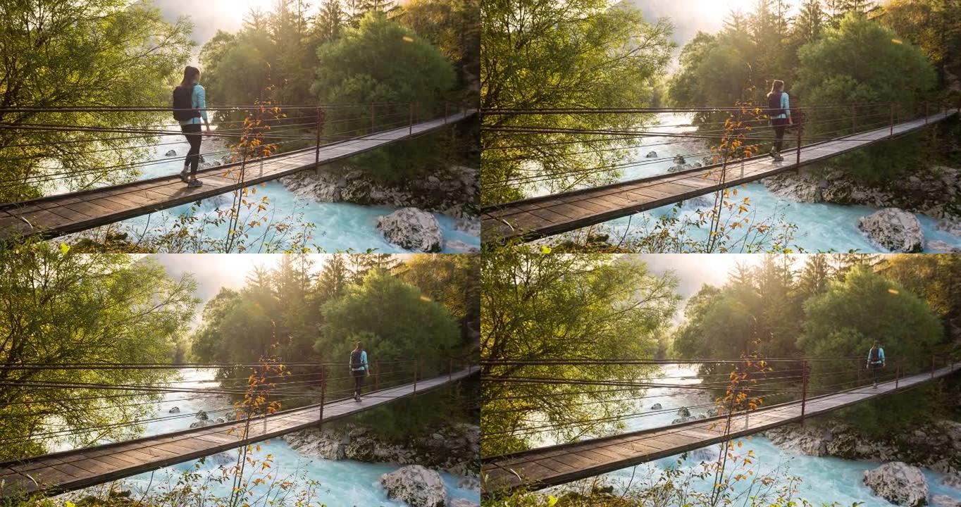 年轻女子越过木吊桥越过山溪，风景充满活力