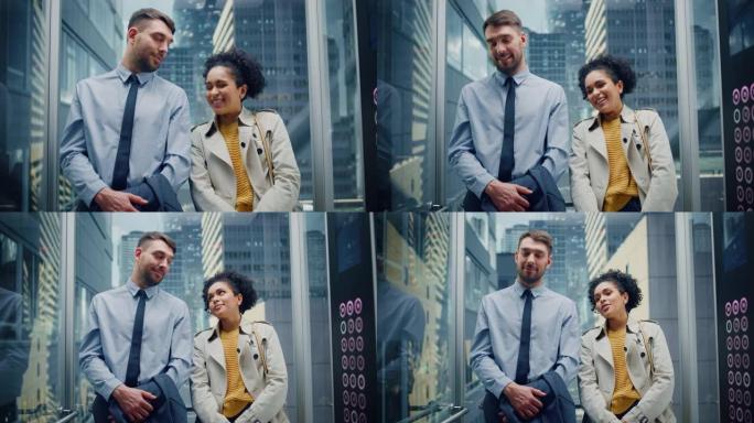 在现代商务中心的玻璃电梯中，两名办公室同事在下班途中交谈。高加索男性专家和黑人拉丁美洲女经理在电梯里