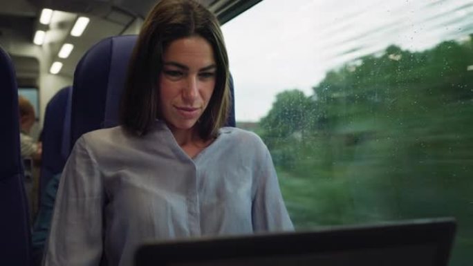 成功的女商人在乘火车旅行时发送电子邮件和在笔记本电脑上工作的电影镜头。女性首席执行官保持联系并使用互