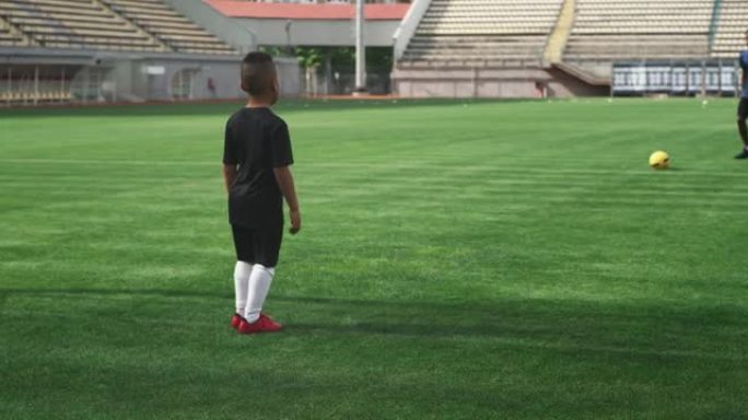 黑人父亲向儿子踢足球