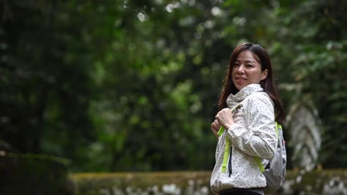 一位亚洲华裔美女在丛林雨林远足径中远望