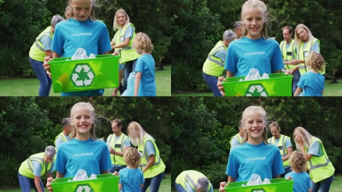 微笑的高加索女孩拿着回收箱在野外与志愿者一起捡拾垃圾