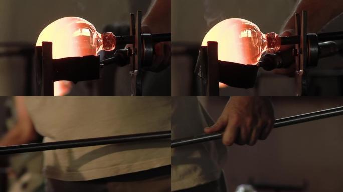 玻璃鼓风机在玻璃厂塑造熔融玻璃的气泡。特写。