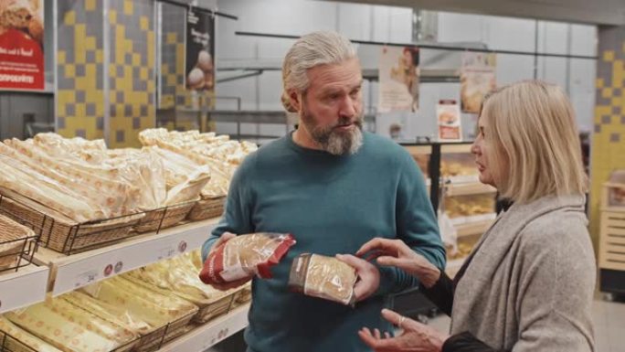 成年夫妇在超市选择新鲜面包店