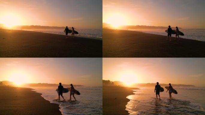 空中轮廓: 跟随冲浪者在金色日出时沿着海滩散步