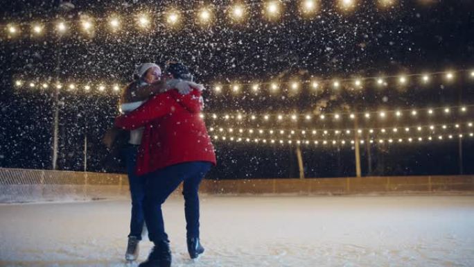浪漫的冬天下雪的夜晚: 滑冰夫妇在溜冰场上玩得开心。双人滑冰男孩和女友恋爱，跳舞，旋转拥抱，职业花样