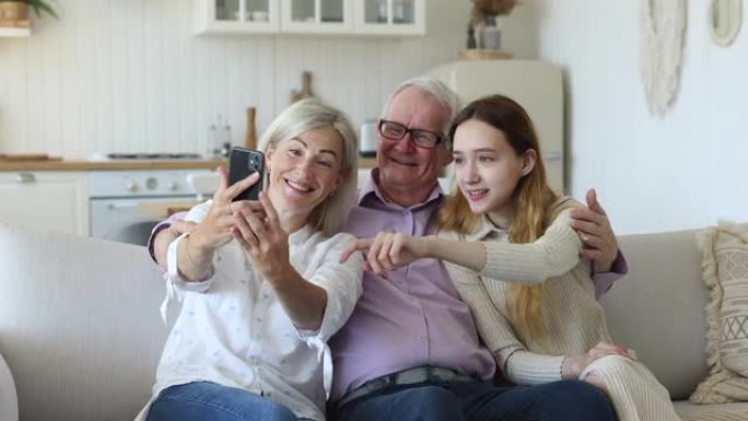 多代家庭盯着手机屏幕，玩得开心，自拍