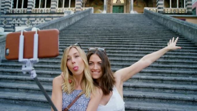 两个快乐的女人在意大利的一座教堂前一起自拍度假