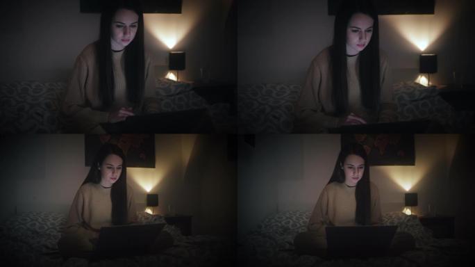 美女在床上晚上用笔记本电脑工作