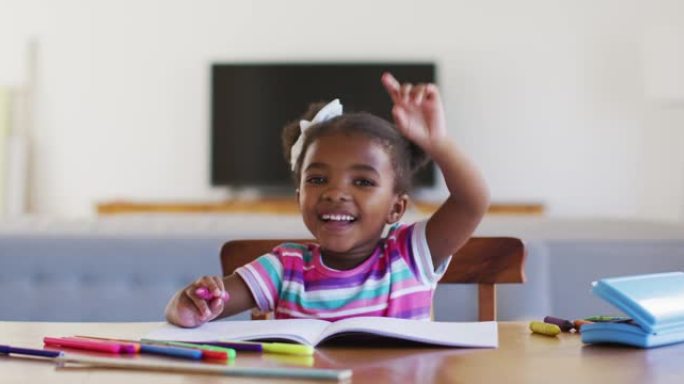 快乐的非洲裔美国女孩在家上网校时举手