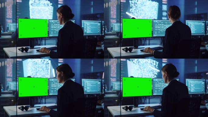 自信的女性数据科学家在带有神经网络的大型基础设施控制和监控室中使用绿屏模型在个人计算机上工作。和同事