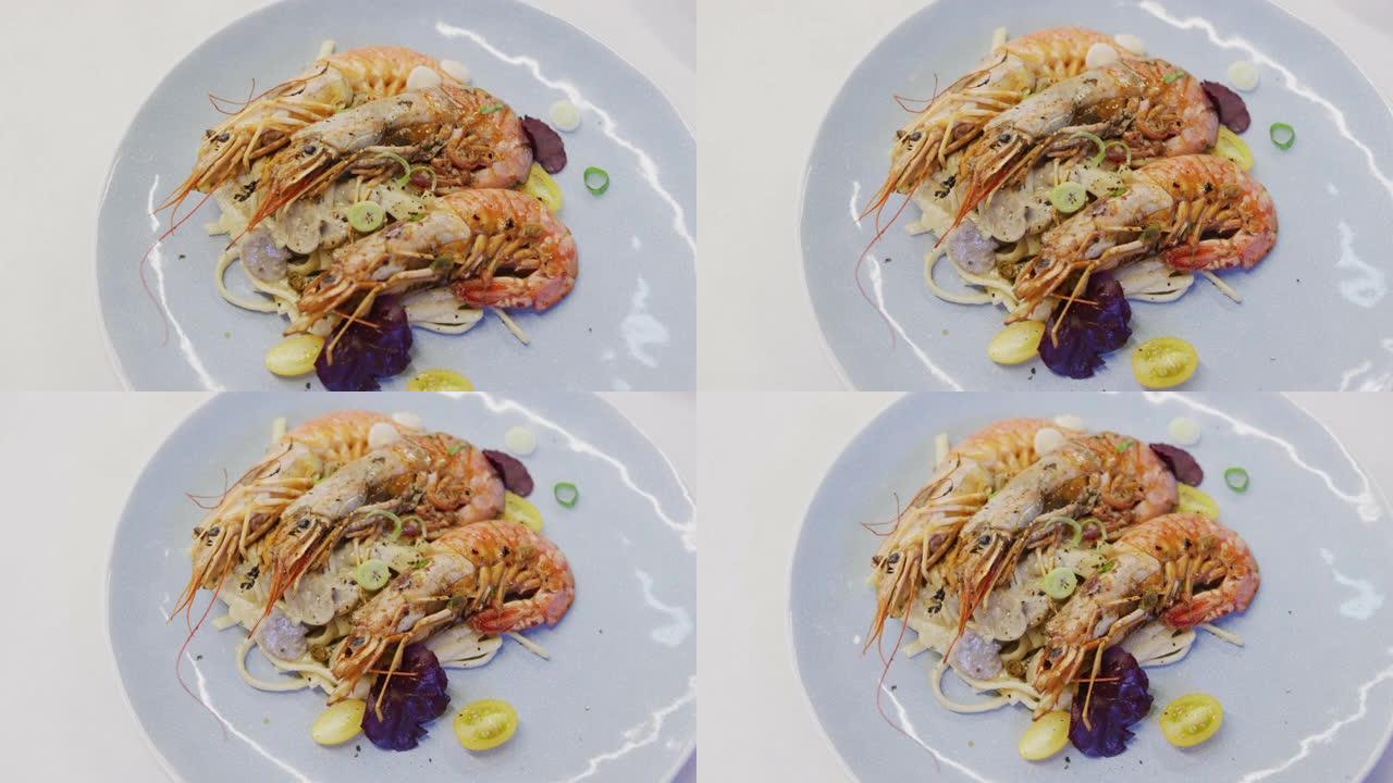 新鲜虾配意大利面和蔬菜放在白色盘子里