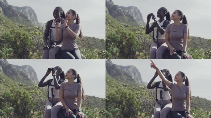 两名年轻妇女在远足期间坐着并使用双筒望远镜的4k视频片段