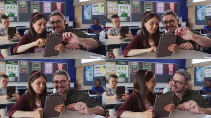 多元化的男老师使用平板电脑帮助坐在教室里的女学生