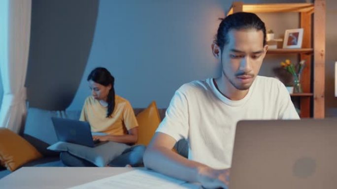 自由职业者亚洲夫妇在晚上感到认真专注于工作单独的笔记本电脑。