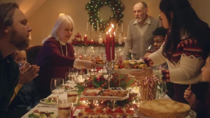 快乐多样的家庭为圣诞餐桌服务